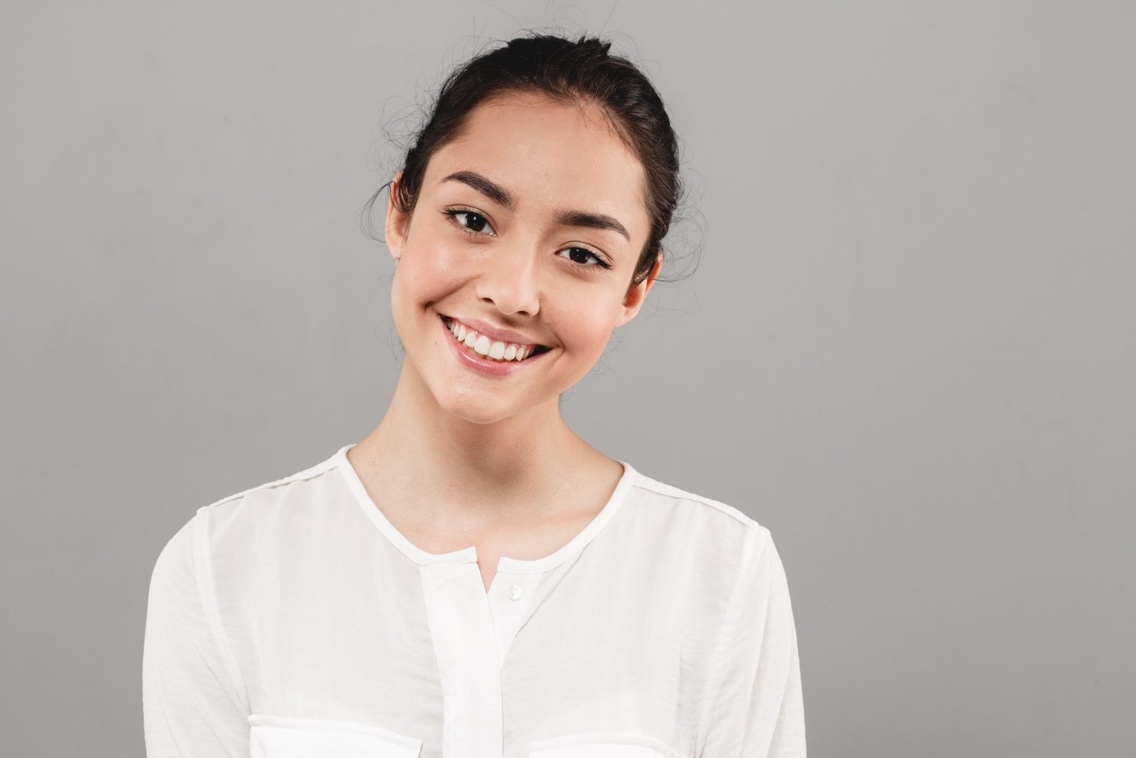 Smiling Woman In White Shirt On Grey Background 2026 03 18 16 10 40 Utc